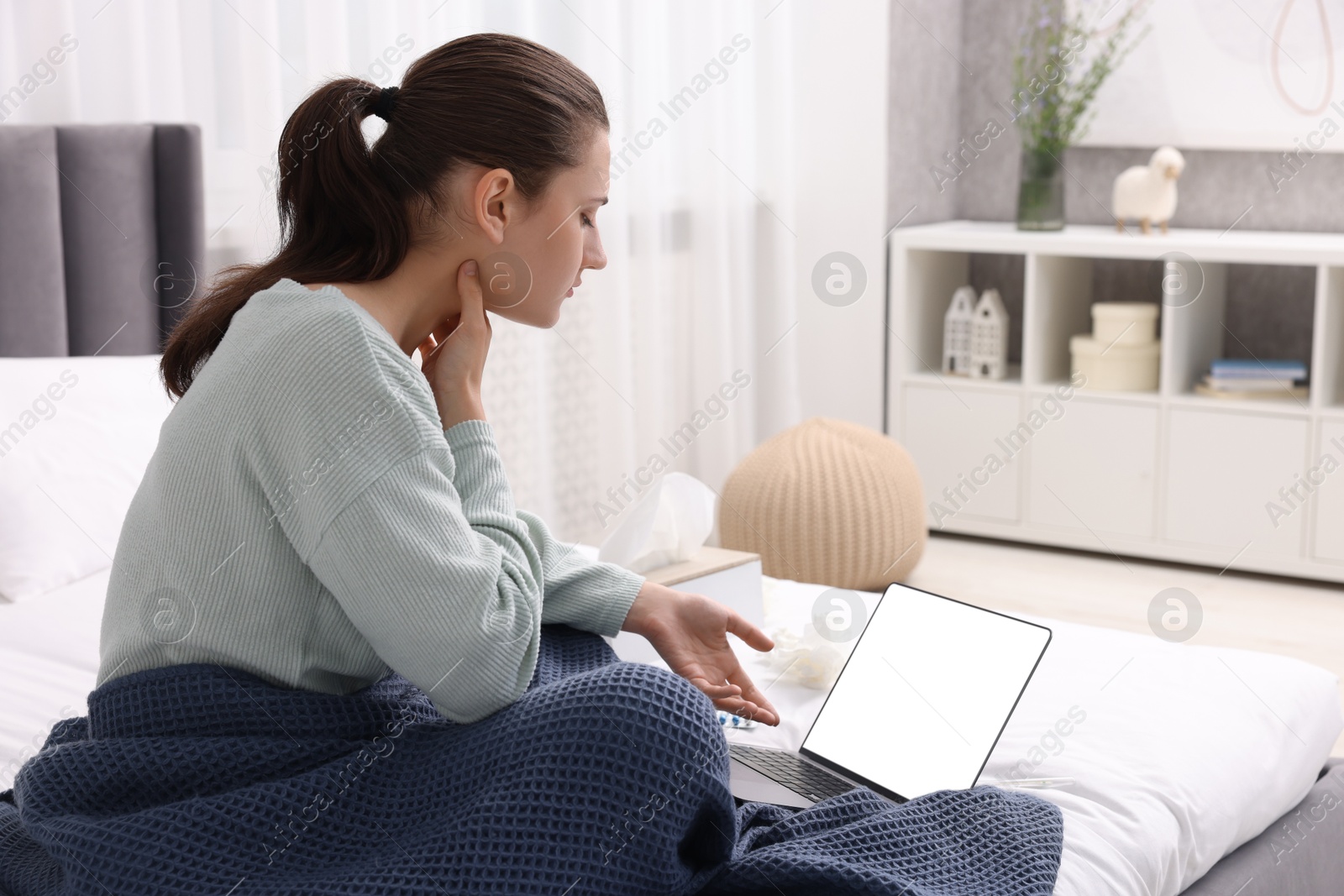 Photo of Sick woman having online consultation with doctor via laptop at home