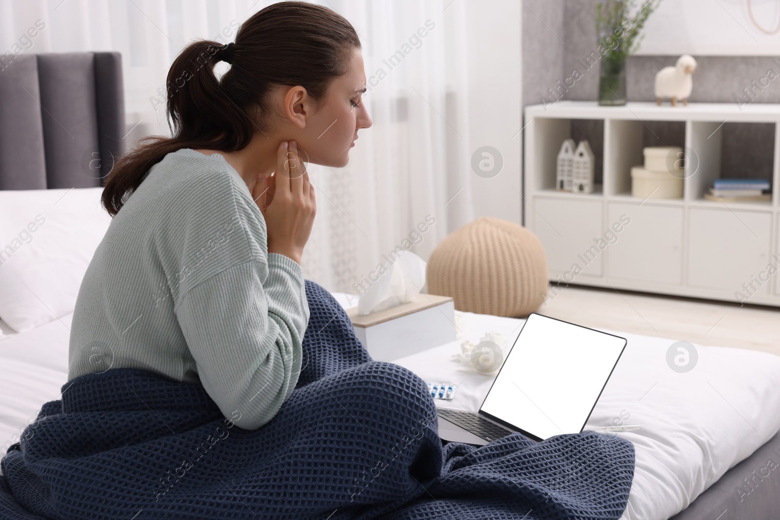 Photo of Sick woman having online consultation with doctor via laptop at home