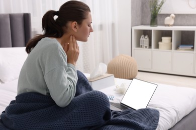 Sick woman having online consultation with doctor via laptop at home