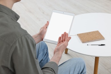 Photo of Sick man having online consultation with doctor via tablet at home, closeup