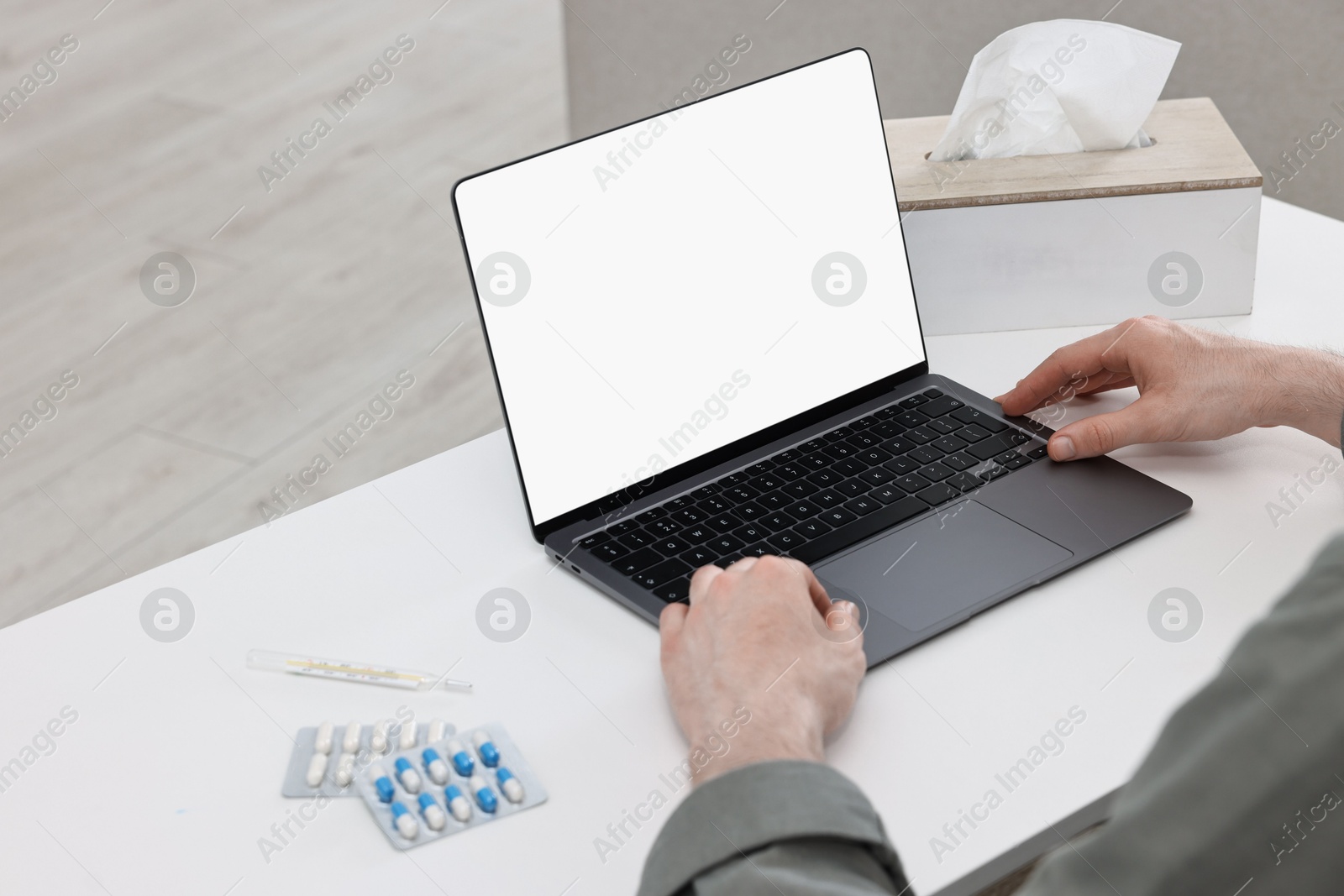 Photo of Sick man having online consultation with doctor via laptop at white table indoors, closeup