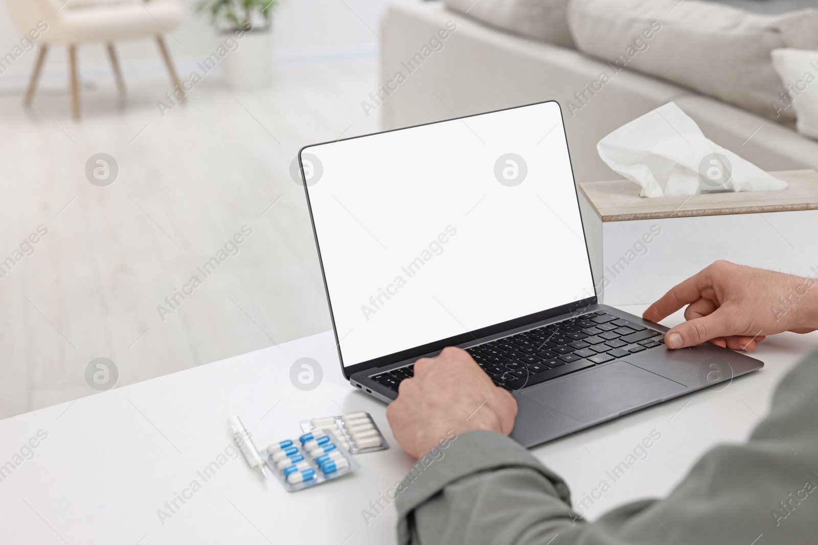 Photo of Sick man having online consultation with doctor via laptop at white table indoors, closeup