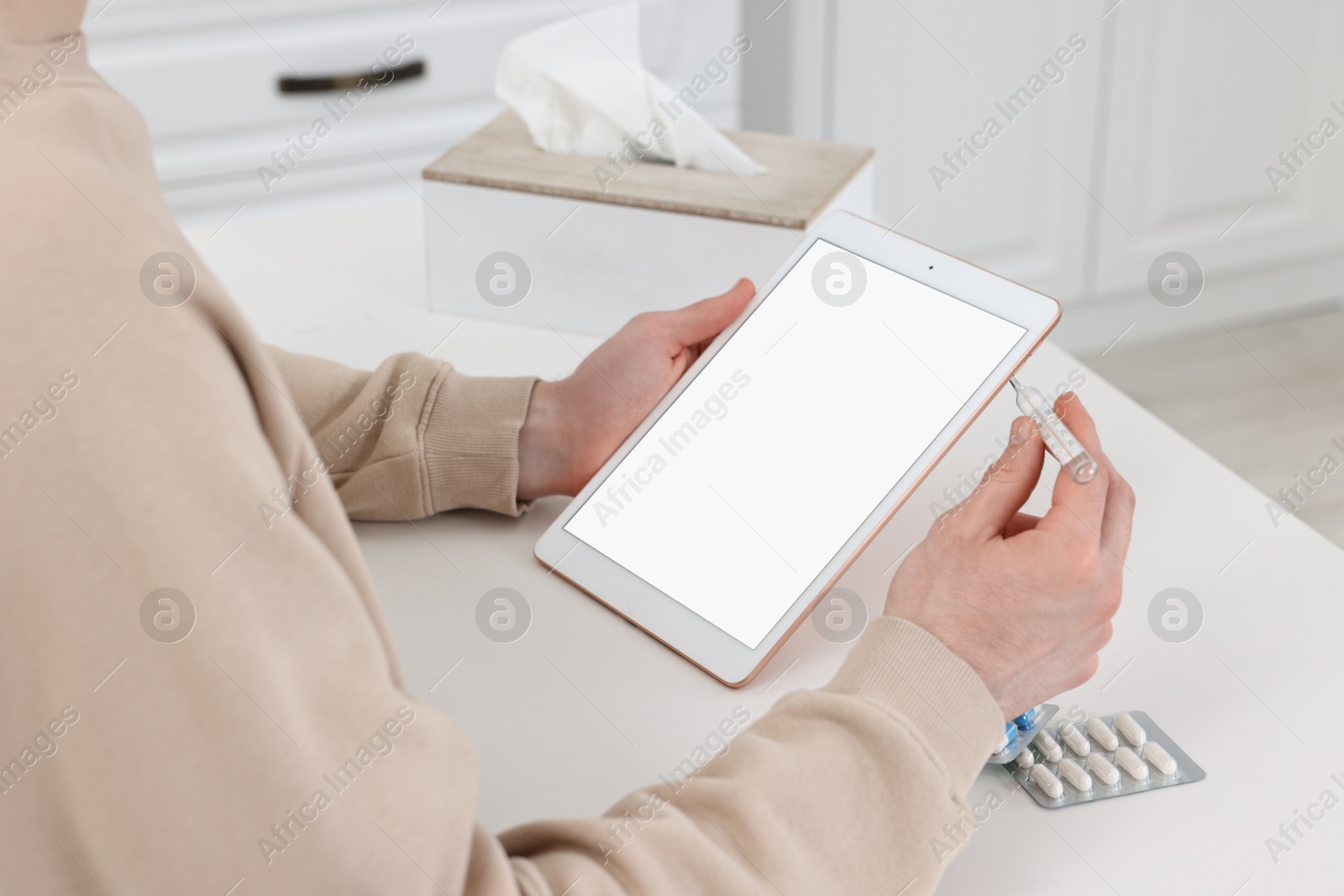 Photo of Sick man having online consultation with doctor via tablet at white table indoors, closeup