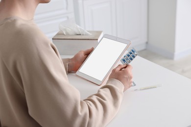 Photo of Sick man having online consultation with doctor via tablet at white table indoors, closeup