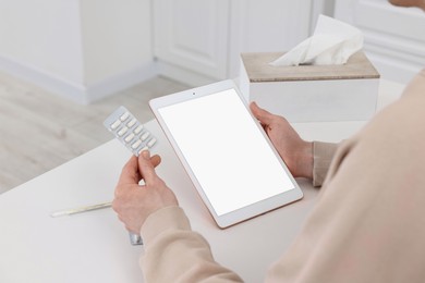 Photo of Sick man having online consultation with doctor via tablet at white table indoors, closeup