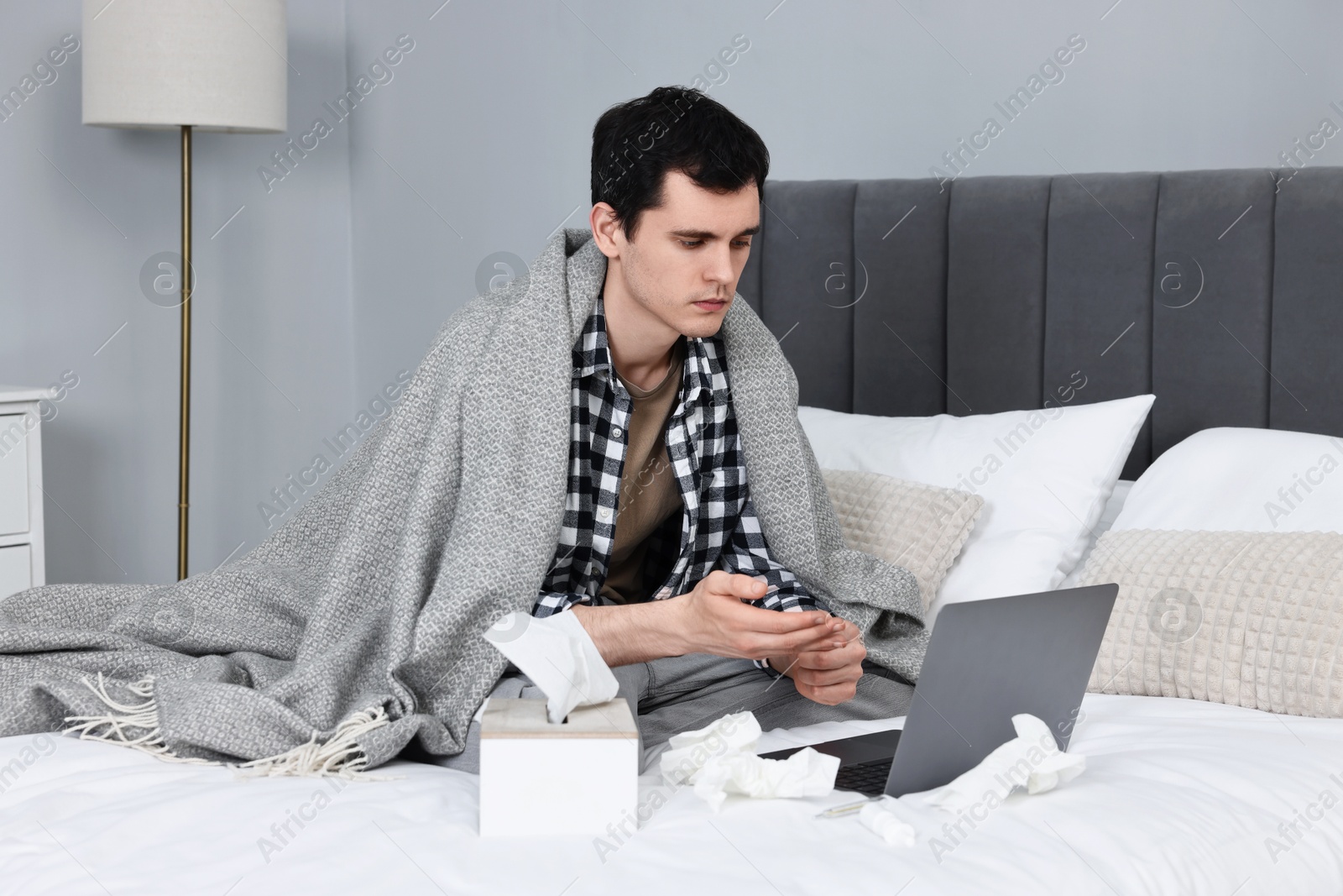 Photo of Sick man having online consultation with doctor via laptop at home