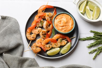 Photo of Skewers with delicious grilled shrimps served on white table, flat lay