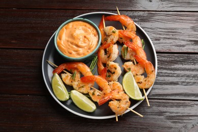 Photo of Skewers with delicious grilled shrimps served on wooden table, top view