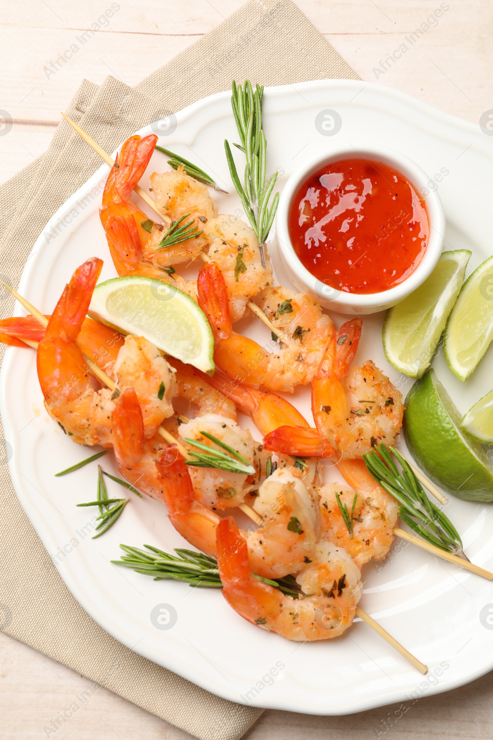 Photo of Skewers with delicious grilled shrimps served on wooden table, top view