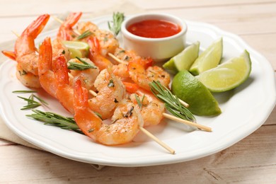 Photo of Skewers with delicious grilled shrimps served on wooden table