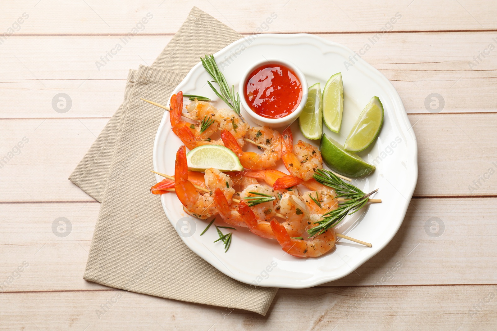 Photo of Skewers with delicious grilled shrimps served on wooden table, top view