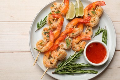 Photo of Skewers with delicious grilled shrimps served on wooden table, top view