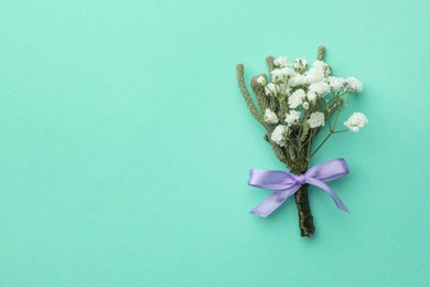 Photo of Small stylish boutonniere on turquoise background, flat lay. Space for text