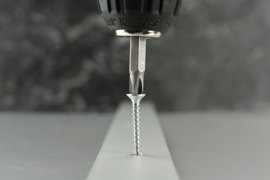 Photo of Screwing screw into white panel at light table, closeup