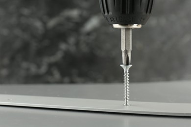 Photo of Screwing screw into white panel at light table, closeup. Space for text