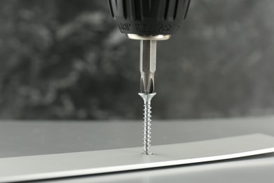 Photo of Screwing screw into white panel at light table, closeup