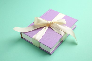 Book tied with beige ribbon on turquoise background