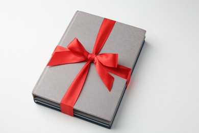 Books tied with red ribbon on white background