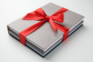 Books tied with red ribbon on white background