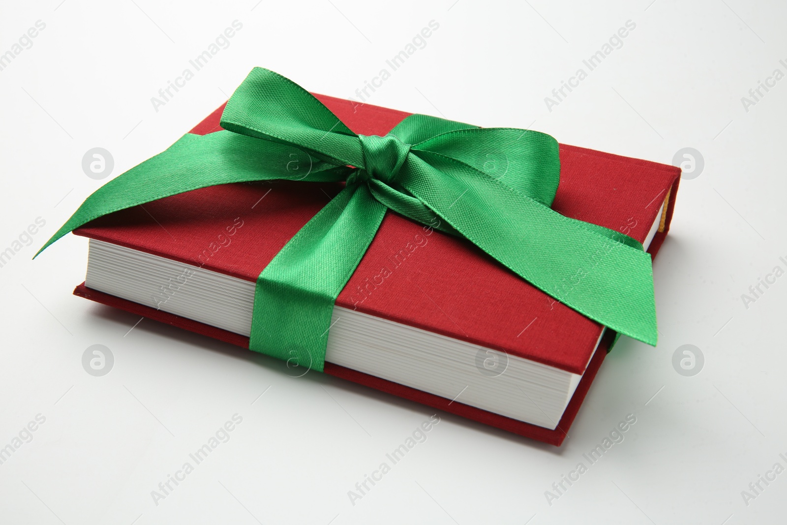 Photo of Book tied with green ribbon on white background