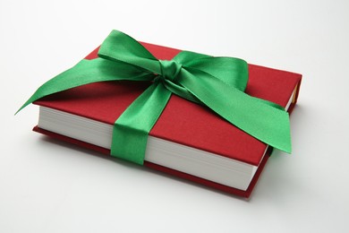 Photo of Book tied with green ribbon on white background