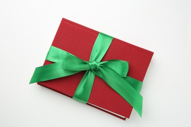 Photo of Book tied with green ribbon on white background, top view