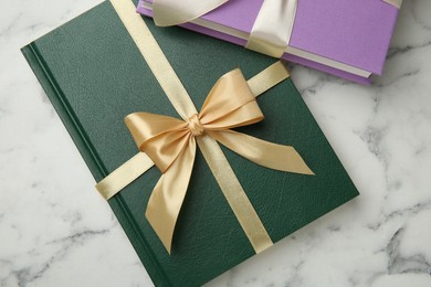 Photo of Books tied with ribbons on white marble table, top view