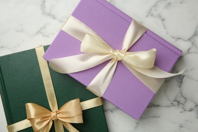 Photo of Books tied with ribbons on white marble table, top view