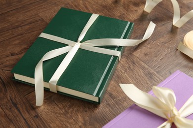 Hardcover books and ribbon as gift on wooden table