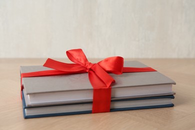 Hardcover books with ribbon as gift on wooden table