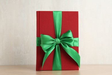 Hardcover book with ribbon as gift on wooden table