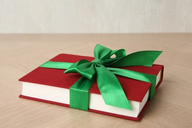 Hardcover book with ribbon as gift on wooden table