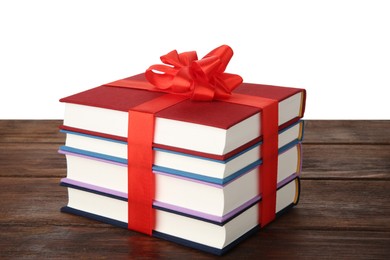 Photo of Stack of books with ribbon as gift on wooden table against white background