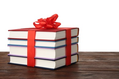 Stack of books with ribbon as gift on wooden table against white background