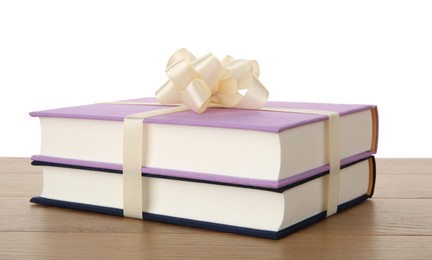 Hardcover books with ribbon as gift on wooden table against white background