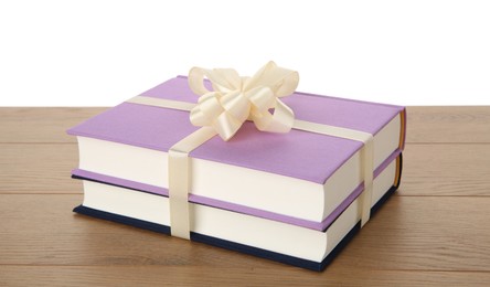 Photo of Hardcover books with ribbon as gift on wooden table against white background