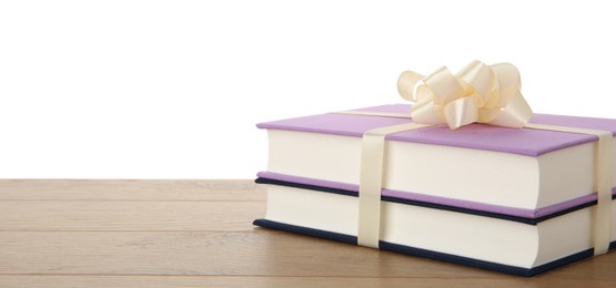 Photo of Hardcover books with ribbon as gift on wooden table against white background