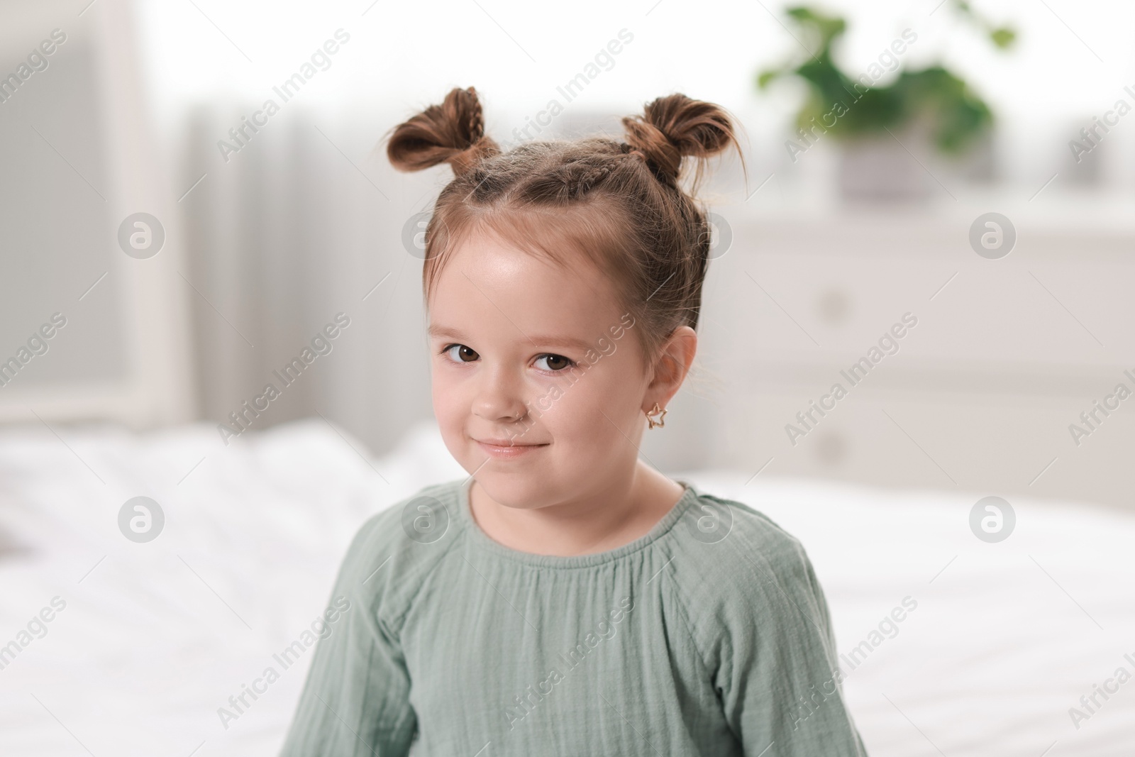 Photo of Portrait of beautiful little girl in bedroom. Cute child