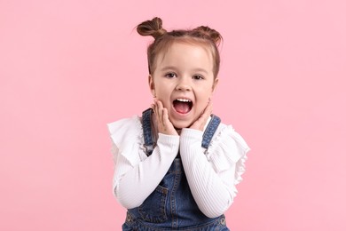 Photo of Portrait of emotional little girl on pink background