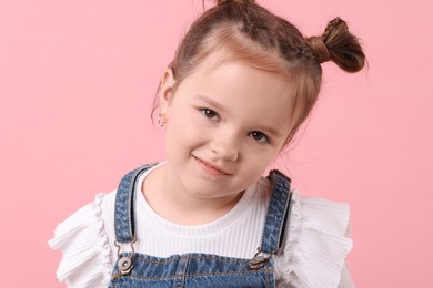 Photo of Portrait of cute little girl on pink background