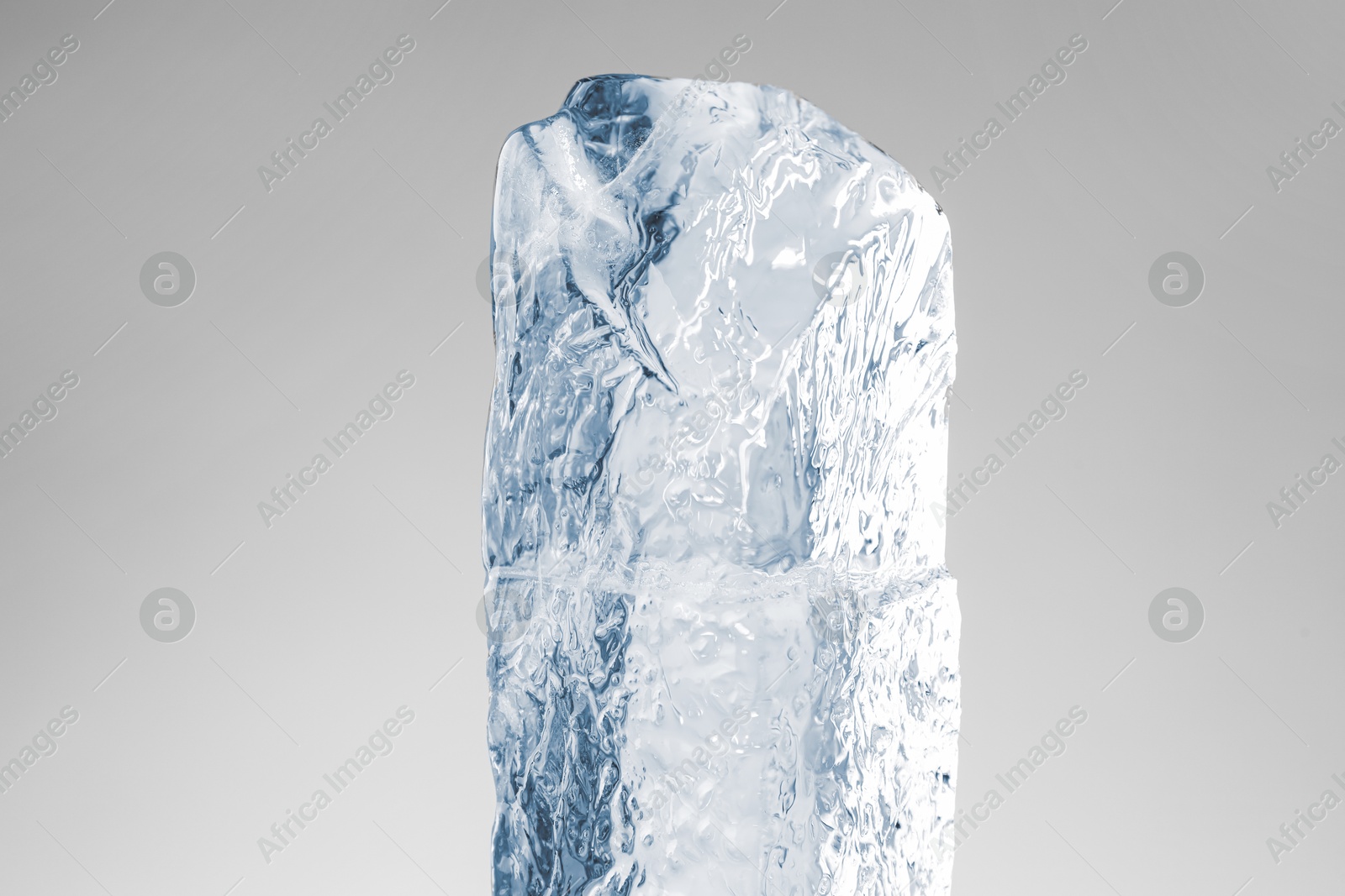 Photo of Piece of clear ice on light grey background