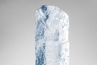 Photo of Piece of clear ice on light grey background