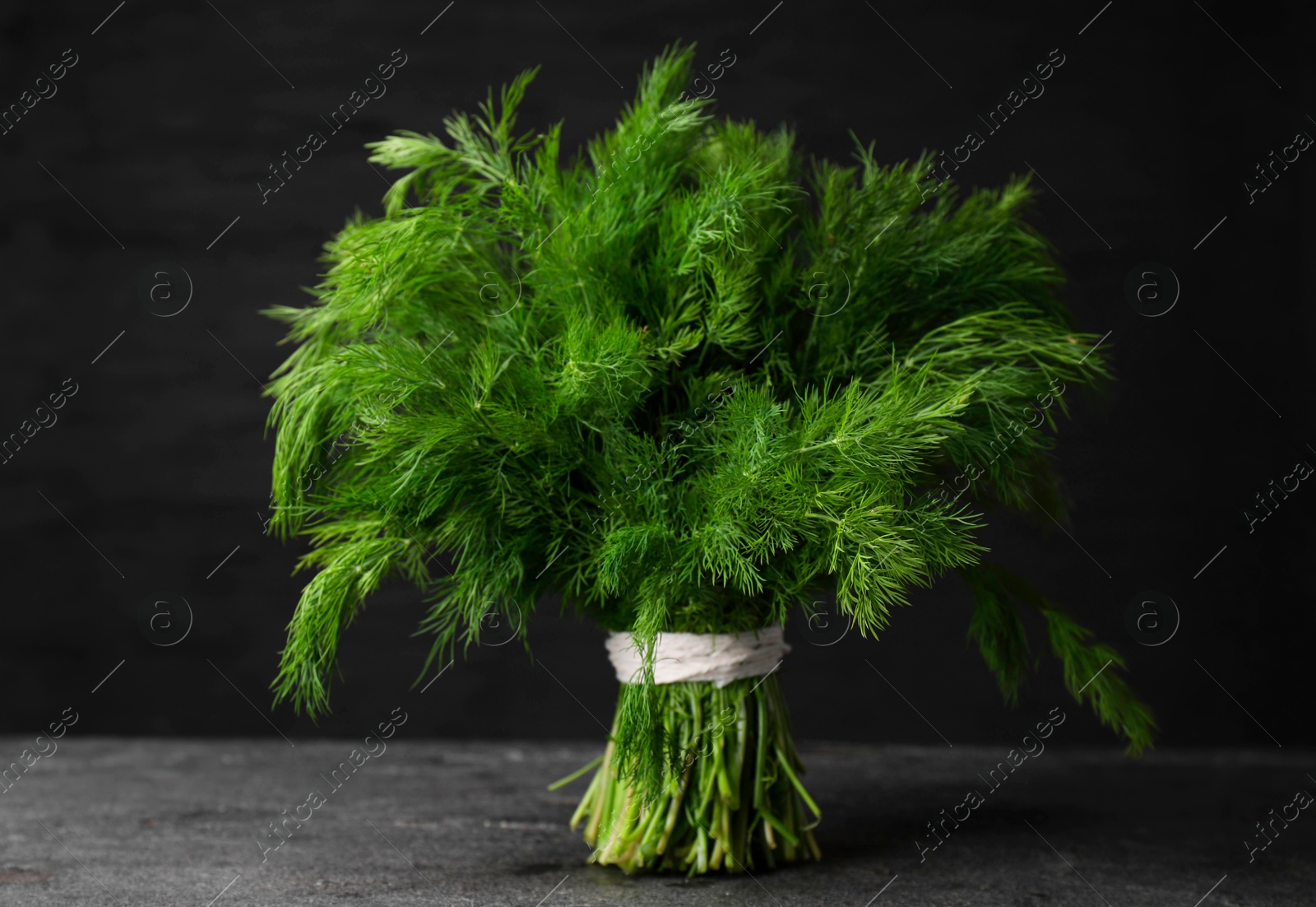 Photo of Bunch of fresh green dill on grey table