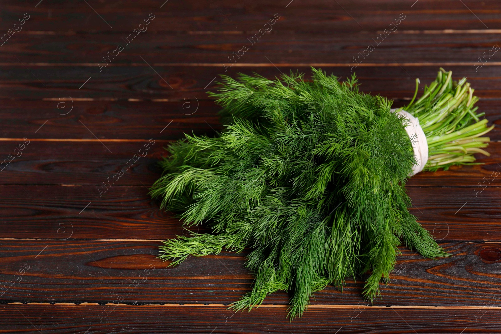 Photo of Bunch of fresh green dill on wooden table, space for text