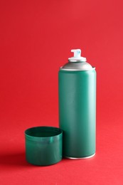 Photo of One green spray paint can on red background