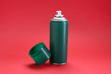 One green spray paint can on red background