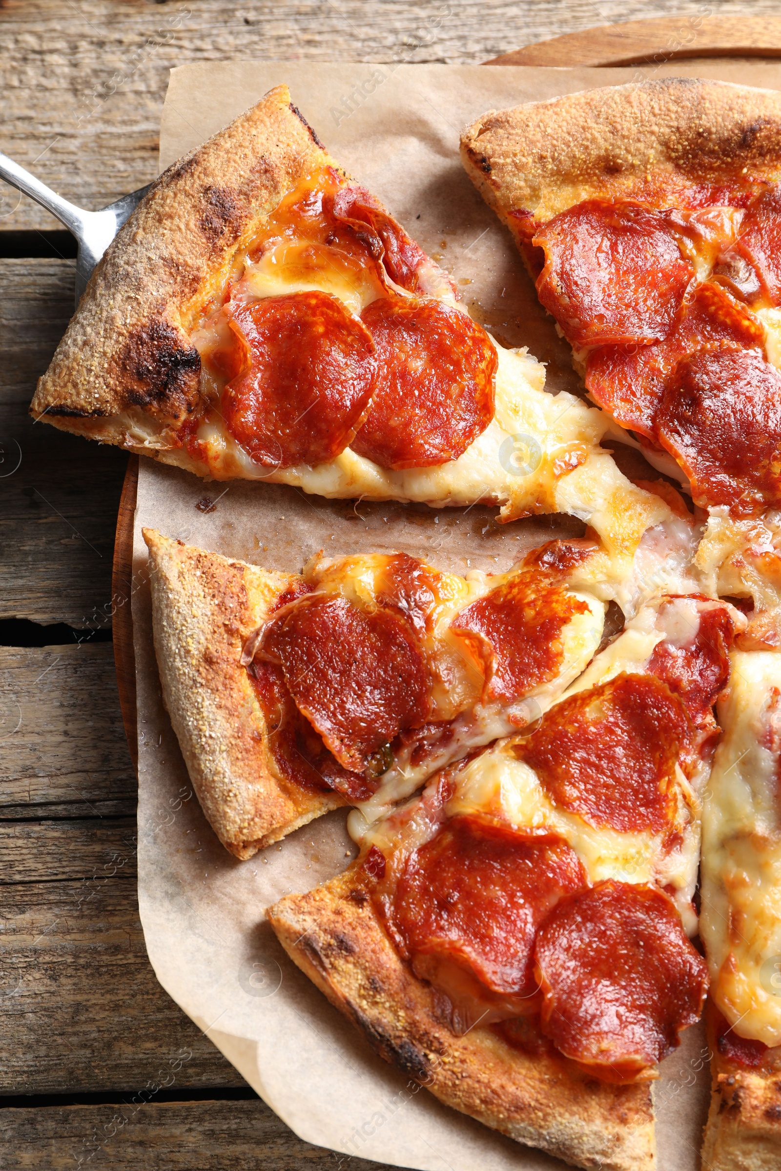 Photo of Tasty pepperoni pizza on wooden table, top view