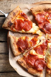 Tasty pepperoni pizza on wooden table, top view