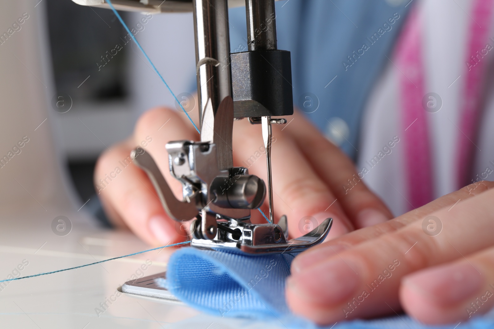 Photo of Seamstress working with sewing machine indoors, closeup