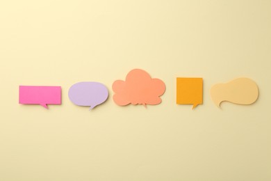 Equality concept. Different paper speech bubbles on beige background, flat lay